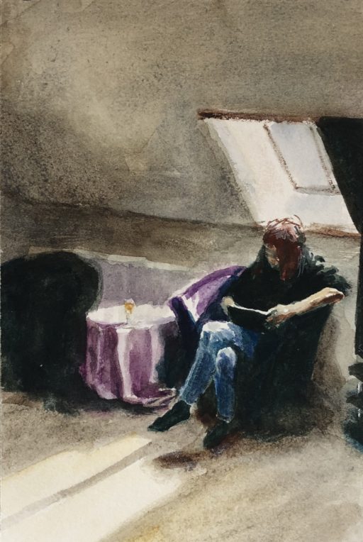 A woman sits in a hotel room reading from a tablet.